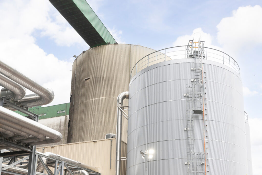 Eine große Industrieanlage mit einem Schichtenspeicher, umgeben von verschiedenen Rohrleitungen und Tanks.