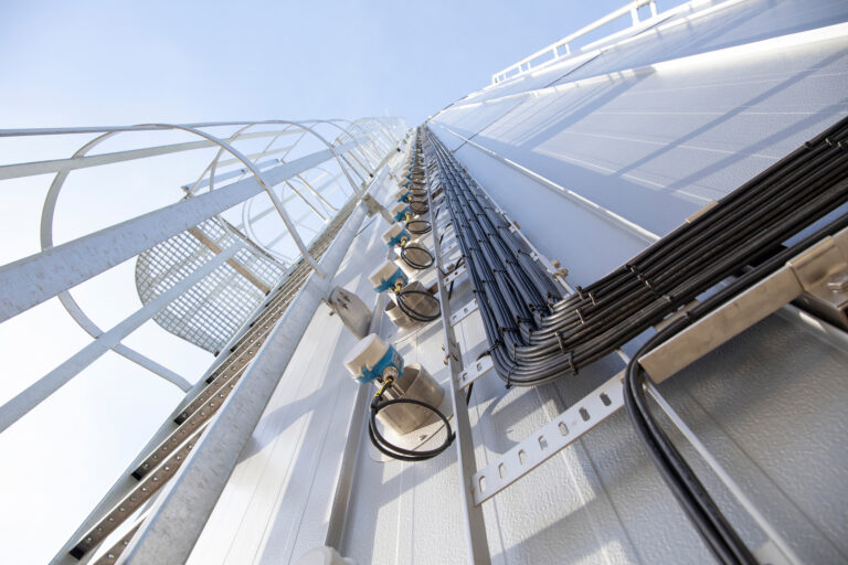 Instrumentation and cabling mounted on the side of a hot water buffer tank at Royal Swinkels