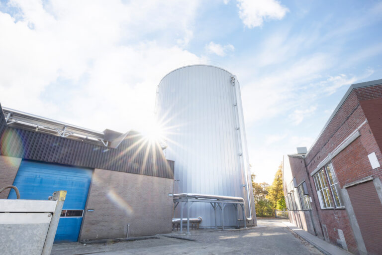 Hot water buffer tank installed at the Royal Swinkels brewery between existing buildings